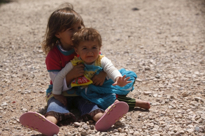 Displaced Iraqi children, who fled from Islamic State violence in Mosul, sit on the ground, on the outskirts of Najaf, south of Baghdad June 24, 2015.