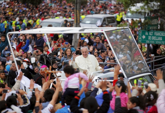 Pope Francis greets the crowd of faithful from a popemobile in Quito, Ecuador, July 5, 2015. Francis landed in Ecuador's capital Quito on Sunday to begin an eight-day tour of South America that will also include visits to Bolivia and Paraguay. On his first visit as pontiff to Spanish-speaking Latin America, the Argentina-born pope is scheduled to conduct masses in both Quito and the coastal city of Guayaquil before flying to Bolivia on Wednesday.