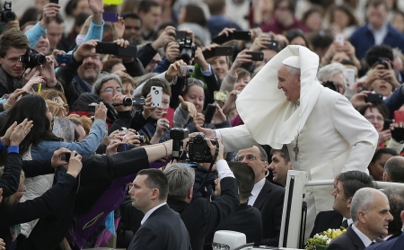 A gust of wind blows Pope Francis's mantle as he arrives to lead his Wednesday general audience in Saint Peter's square at the Vatican, February 19, 2014.