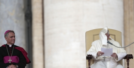 A gust of wind blows Pope Francis' mantle as Archbishop Georg Gaenswein (L) looks at him during the Wednesday general audience in Saint Peter's square at the Vatican, September 11, 2013.