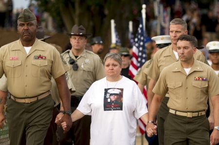 Cathy Wells, the mother of Marine Lance Cpl. Squire K. 'Skip' Wells, who was one of the five military servicemen slain last week in Chattanooga in a domestic terror attack, is escorted by members of the U.S. military at her son's vigil at Sprayberry High School in Marietta, Georgia July 21, 2015. Wells, 21, a reservist, was the youngest victim of an attack being investigated as an act of domestic terrorism. He was killed last Thursday when authorities say Mohammod Youssuf Abdulazeez opened fire at a Naval Reserve Center in Chattanooga, Tennessee, slaying Wells and three other Marines. A sailor later died of his wounds.