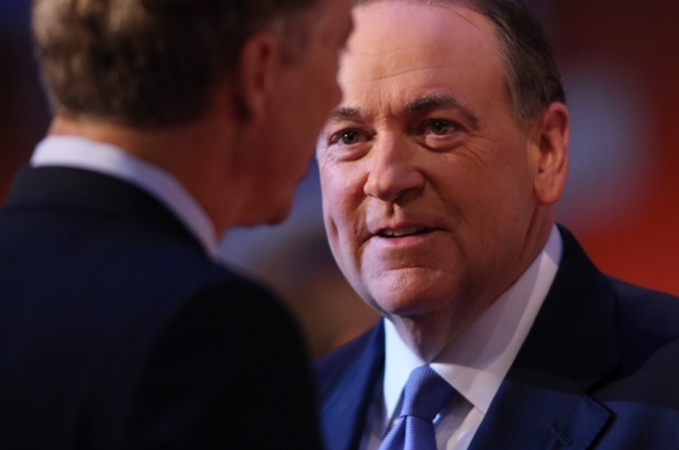 Republican 2016 U.S. presidential candidate former Arkansas Governor Mike Huckabee (R) talks with U.S. Senator and fellow candidate Rand Paul (L) during a commercial break at the first official Republican presidential candidates debate of the 2016 U.S. presidential campaign in Cleveland, Ohio, August 6, 2015.