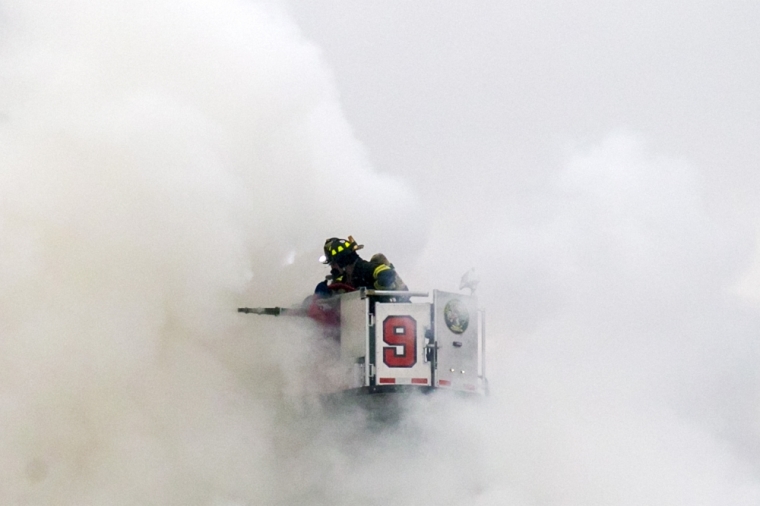 New York City Fire Department firefighters battle fire at the site of a residential apartment building collapse and fire in New York City's East Village neighborhood, March 26, 2015. An apparent gas explosion caused two apartment buildings to collapse and burst into flames, and two others to catch fire, injuring at least 12 people on Thursday in New York City's East Village neighborhood, authorities said.