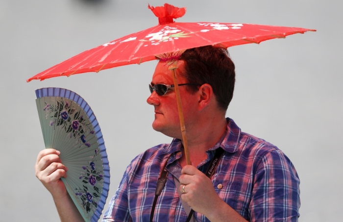 A faithful shelters from the sun with an umbrella as Pope Francis leads the Angelus prayer from the window of the Apostolic palace in Saint Peter's Square at the Vatican, July 19, 2015. A heat wave coming from Africa is spreading across Italy with temperatures forecast to reach 40 degrees Celsius (104 degrees Fahrenheit), reported local weather officials.