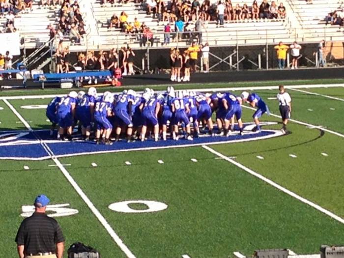 The Bell County High School football team huddles up before their 2015 season opener against Middlesboro High School in Pineville, Kentucky on Aug, 21, 2015.