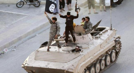 ISIS fighters participate in a street parade in Raqqa on June 30, 2014.