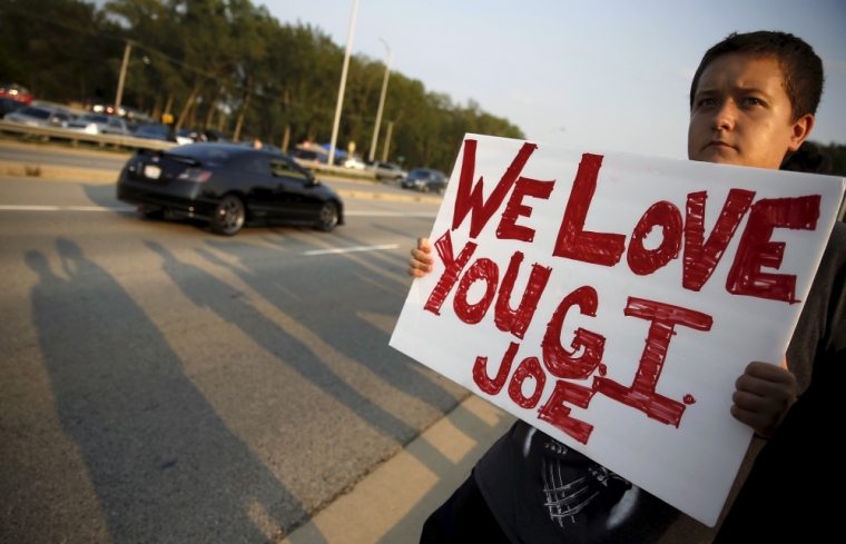 A supporter of Fox Lake Police Lieutenant Charles Joseph Gliniewicz who was also known as 'G.I. Joe' stands in memory of the slain police officer in Fox Lake, Illinois, United States, September 1, 2015. Police with dogs and helicopters are searching woods and swampy areas north of Chicago for three armed suspects after a police officer was shot dead on Tuesday in the suburb of Fox Lake, a local law enforcement official said.