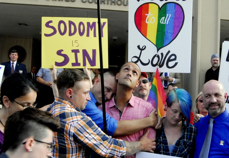 Demonstrators stand on the front steps of the federal building waving a rainbow flag in protest of Rowan County clerk Kim Davis' arrival to attend a contempt of court hearing for her refusal to issue marriage certificates to same-sex couples at the United States District Court in Ashland, Kentucky, September 3, 2015.