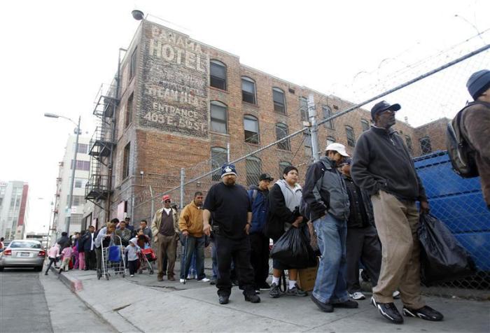 People line up for an early Thanksgiving meal served to the homeless at the Los Angeles Mission in downtown Los Angeles, November 24, 2010.