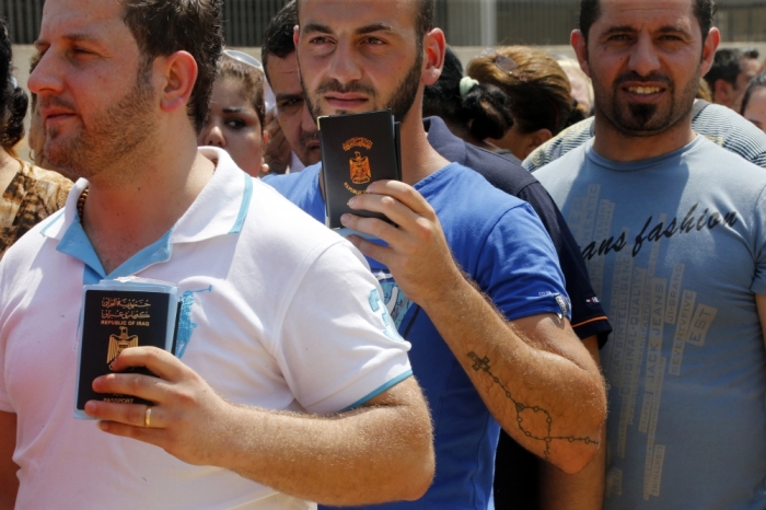 Iraqi Christians displaced by the violence in their country wait in line to receive aid from a Chaldean Catholic Church truck in Beirut August 13, 2014. Well financed and armed, Islamic State insurgents have captured large swathes of territory in a summer offensive, as the Iraqi army - and now Kurdish Peshmerga forces in the self-governing north - have crumbled in the face of its onslaught, massacring Shiites and minority Christians and Yazidis as they advance.