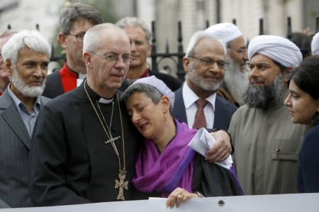 The Archbishop of Canterbury, Justin Welby (2L), Senior Rabbi Laura Janner-Klausner (C), Imam Shaykh Ibrahim Mogra (2R) and Sayeeda Warsi (R) react together at the close of a vigil outside Westminster Abbey in central London September 3, 2014.