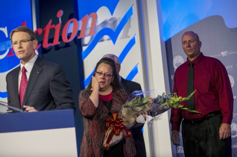 Kentucky's Rowan County Clerk Kim Davis, who was briefly jailed for refusing to issue marriage licenses to same-sex couples, receives the 'Cost of Discipleship' award from Family Research Council President Anthony Perkins (L) as Davis' husband Joe Davis looks on at a Family Research Council conference in Washington, September 25, 2015.