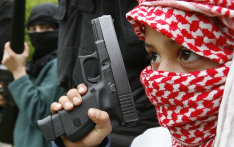 Palestinian fighters of the Fatah al-Islam group undergo military training with children in Nahr al-Bared refugee camp in northern Lebanon March 23, 2007. The group founder, Shaker al-Abssi, has come under the spotlight in Lebanon since November when he and 200 fighters broke off from the pro-Syrian Fatah Uprising group and founded their own faction: Fatah al-Islam. The group quickly earned notoriety and was alternately linked to al Qaeda and Syria, raising fears that Lebanon could witness large-scale attacks on Western and other targets. Picture taken March 23, 2007.