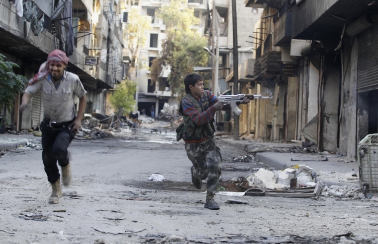 Mohammad (R), a 13 year-old fighter from the Free Syrian Army, aims his weapon as he runs from snipers loyal to the Syrian regime in Aleppo's Bustan al-Basha district October 29, 2013. Mohammad joined the Free Syrian Army after his father died during clashes with the Syrian regime. The gun he is using was his father's.