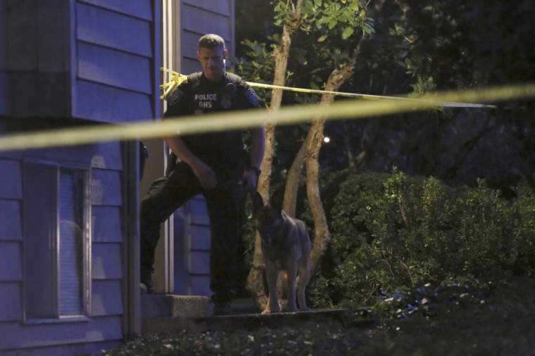 A DHS police investigator is seen with a canine at residential location following a mass shooting at Umpqua Community College in Roseburg, Oregon, October 1, 2015. A gunman opened fire at a community college in southwest Oregon on Thursday, killing nine people and wounding seven others before police shot him to death, authorities said, in the latest mass killing to rock an American campus.