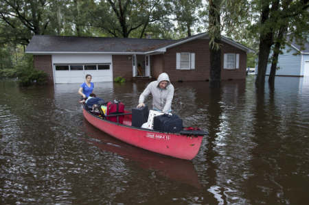 Greg Rodermond (R) and Mandy Barnhill, use a canoe to evacuate Mandy's home on Long Avenue in Conway, South Carolina, October 5, 2015.