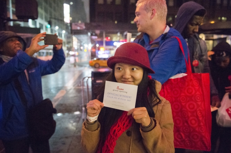 Zhikuo Wong, 19, holds a certificate after being the first to enter a Chick-fil-A freestanding franchise restaurant during its grand opening in Midtown, New York, October 3, 2015.