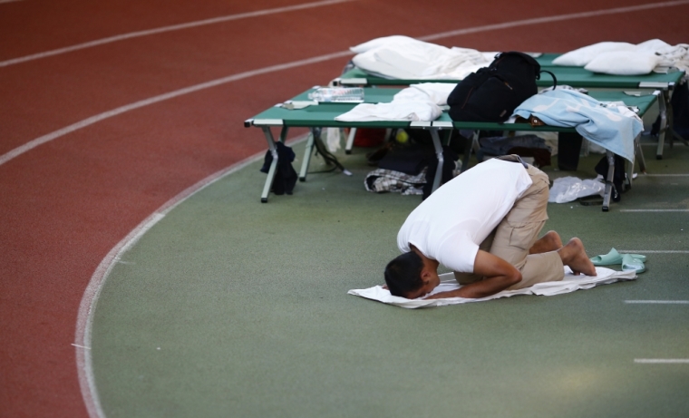 A migrant prays at an temporary shelter in a sports hall in Hanau, Germany, September 29, 2015. When the flood of Middle Eastern refugees arriving in Europe finally ebbs and asylum-seekers settle down in their new homes, Germany could unexpectedly find itself housing the continent's largest Muslim minority.