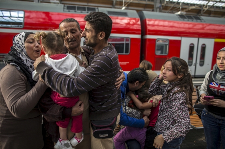 Ihab, 30 (C), a Syrian migrant from Deir al-Zor, cries as he and his family are welcomed by his relatives upon their arrival at the railway station in Lubeck, Germany, September 18, 2015.