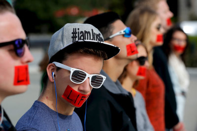 Members of the anti-abortion protest group Bound 4 Life wear red tape over their mouths reading 'Life' as they demonstrate at the U.S. Supreme Court building on the first day of the court's new term in Washington, October 5, 2015. 