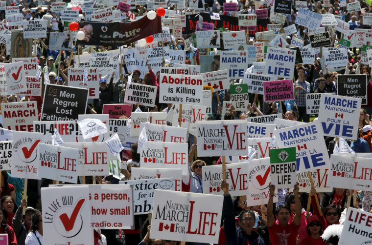 Demonstrators hold signs during an anti-abortion protest on Parliament Hill in Ottawa May 14, 2015.