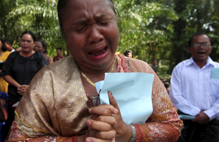 A resident cries as she prays during a Sunday mass near a burned church at Suka Makmur Village in Aceh Singkil, Indonesia Aceh province, October 18, 2015. Hardline Muslims in Indonesia's conservative Aceh province on Sunday demanded the local government close 10 Christian churches, just days after a mob burnt down a church, leaving one person dead and several injured.