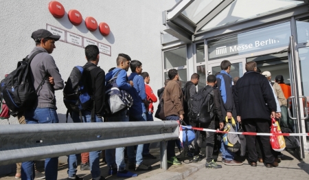 Migrants who arrived earlier by train from Austria, enter a new temporary refugee camp set-up at at Berlin's fairground 'Messe Berlin' in Berlin, Germany, October 5, 2015. German authorities expect up to 1.5 million asylum seekers to arrive in Germany this year, the Bild daily said in a report to be published on Monday, up from a previous estimate of 800,000 to 1 million. Germany's top-selling newspaper cited an internal forecast from authorities that it said had been classed as confidential.