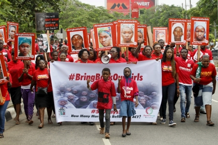 Bring Back Our Girls (BBOG) campaigners hold banners as they walk during a protest procession marking the 500th day since the abduction of girls in Chibok, along a road in Lagos August 27, 2015.