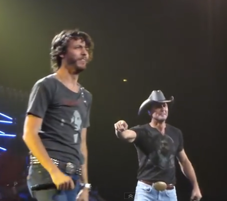 Country music singers Chris Janson and Tim McGraw perform 'Buy Me a Boat' at Nashville's Bridgestone Arena on August 15, 2015.