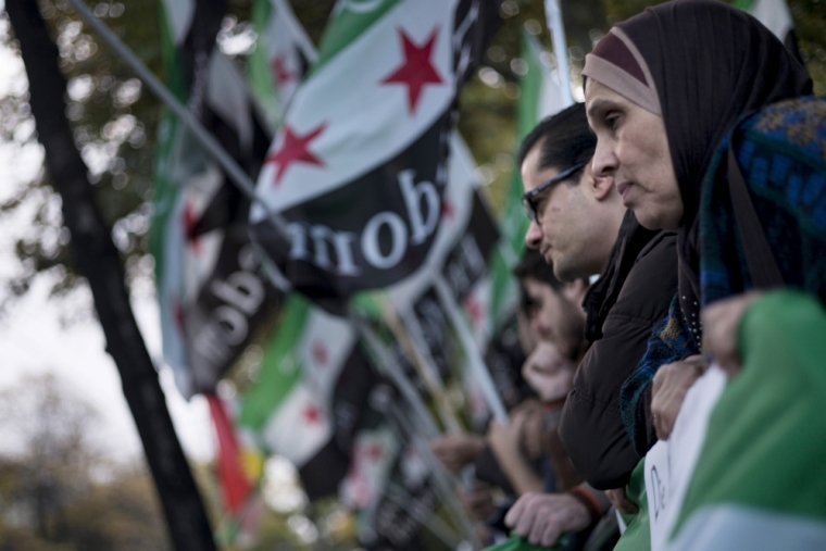 Protesters gather with others across from the Hotel Imperial where U.S. Secretary of State John Kerry and other diplomats discuss Syria, in Vienna, October 30, 2015. U.S. Secretary of State John Kerry said on Friday he hoped progress could be made at international talks in Vienna aimed at finding a political solution to Syria's four-year-old civil war but it would be very difficult.