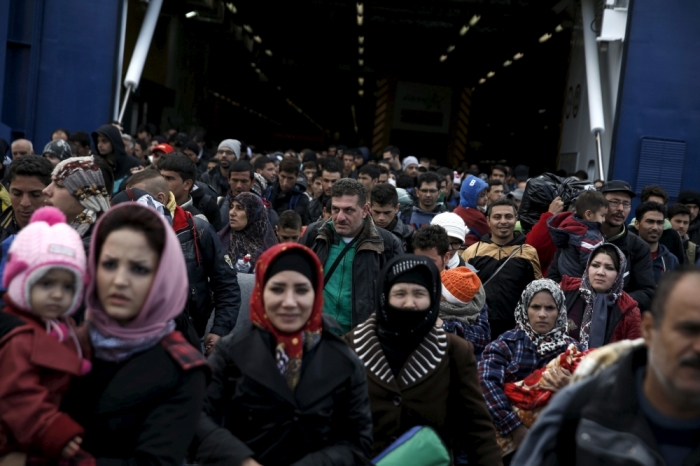 Refugees and migrants arrive aboard the passenger ferry Blue Star Patmos from the island of Lesbos at the port of Piraeus, near Athens, Greece, October 29, 2015. More than half a million migrants have transited through Greece so far this year, many fleeing Syria's civil war on a short but perilous crossing from Turkey on inflatable rubber boats.