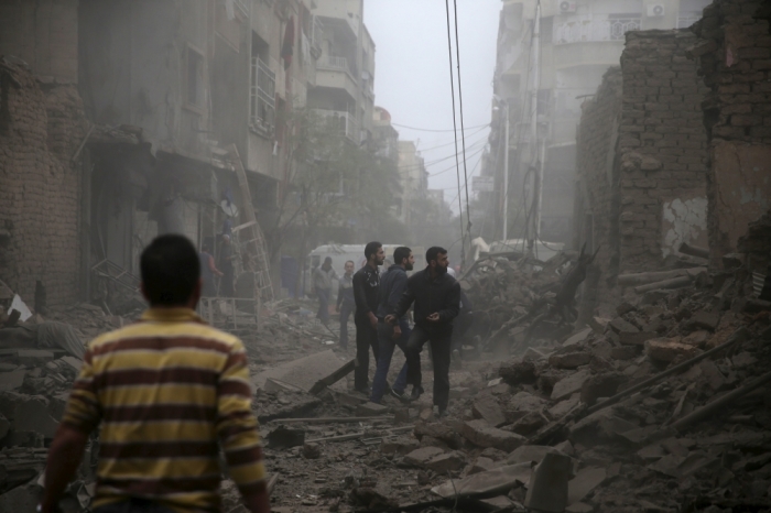 Residents inspect damage from what activists said was an airstrike by forces loyal to Syria's President Bashar al-Assad on the main field hospital in the town of Douma, eastern Ghouta in Damascus, October 29, 2015.