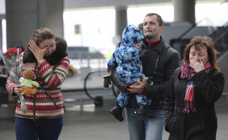 People react near a makeshift memorial for victims of a Russian airliner which crashed in Egypt, outside Pulkovo airport in St. Petersburg, Russia November 1, 2015. Airbus A321, operated by Russian airline Kogalymavia under the brand name Metrojet, carrying 224 passengers crashed into a mountainous area of Egypt's Sinai peninsula on Saturday shortly after losing radar contact near cruising altitude, killing all aboard. Russian President Vladimir Putin declared a day of national mourning for Sunday.