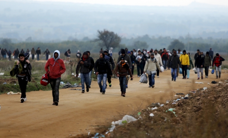 Migrants walk towards a village after entering from Macedonia by foot in Miratovac, Serbia, October 24, 2015. European Commission President Jean-Claude Juncker has called an extraordinary meeting of several European leaders on Sunday to tackle the migrant crisis in the western Balkans as thousands trying to reach Germany are trapped in deteriorating conditions. The Commission said in a statement on Wednesday that Juncker had invited the heads of state or government of Austria, Bulgaria, Croatia, Macedonia, Germany, Greece, Hungary, Romania, Serbia and Slovenia, plus key organisations involved.