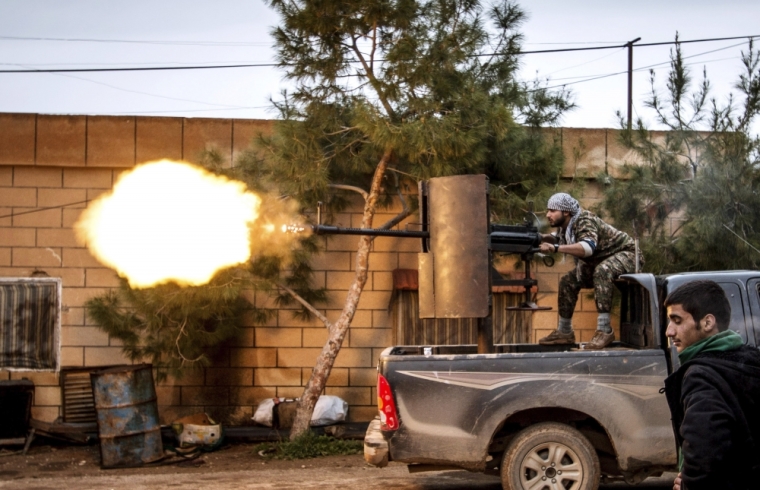 A fighter of the Kurdish People's Protection Units fires an anti-aircraft weapon from Tel Tawil village in the direction of Islamic State fighters positioned in the countryside of the town of Tel Tamr, February 25, 2015. Kurdish militia pressed an offensive against Islamic State in northeast Syria on Wednesday, cutting one of its supply lines from Iraq, as fears mounted for dozens of Christians abducted by the hardline group. The Assyrian Christians were taken from villages near the town of Tel Tamr, some 20 km (12 miles) to the northwest of the city of Hasaka. There has been no word on their fate. There have been conflicting reports on where the Christians had been taken.