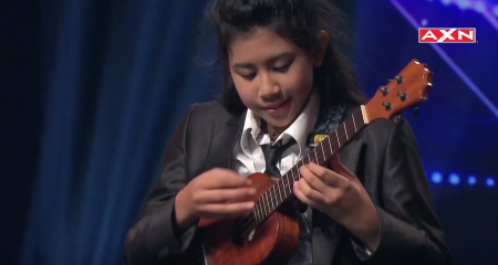 Girl wows talent show by playing ukulele.