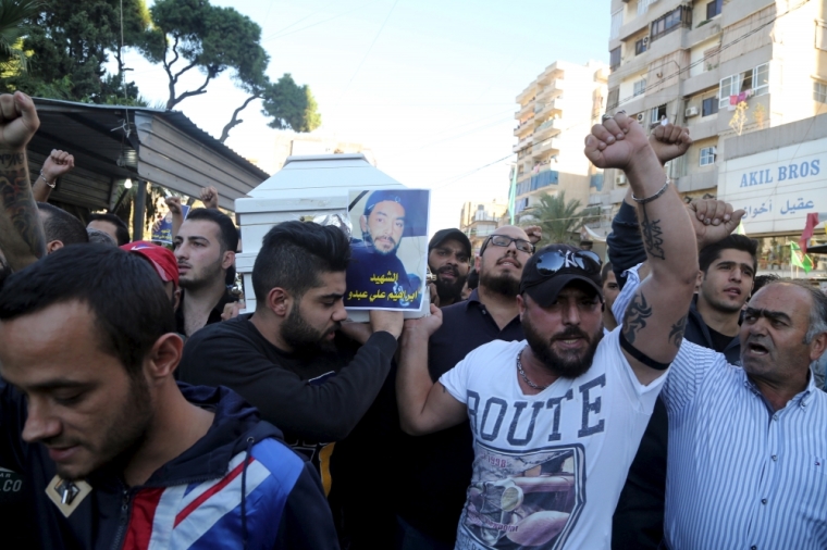 Relatives gesture as they carry the coffin of Ibrahim Ali Abdo, who was killed in the two explosions that occurred on Thursday, during his funeral in the southern suburbs of the Lebanese capital Beirut, November 13, 2015.