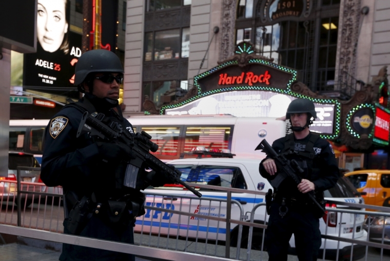 Armed New York City police officers with the special operation division Strategic Response Group stand in front of the U.S. Armed Forces Career Center at Times Square in New York, November 18, 2015.