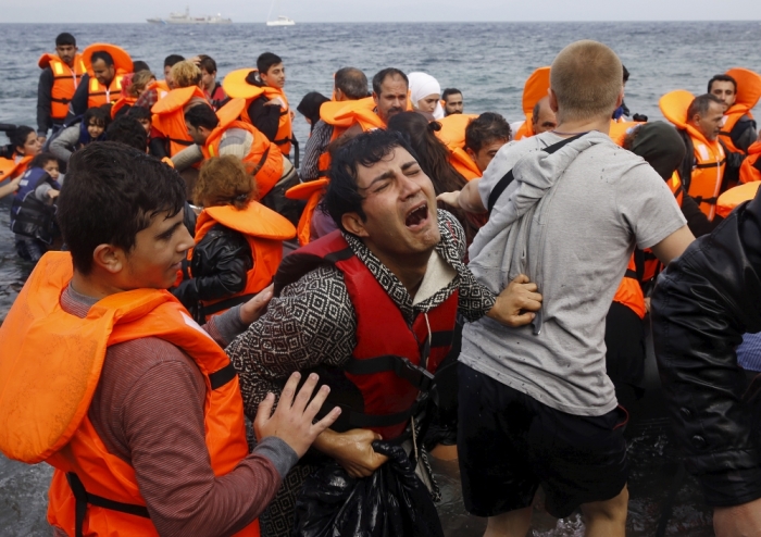 A Syrian refugee cries while disembarking from a flooded raft at a beach on the Greek island of Lesbos, after crossing a part of the Aegean Sea from the Turkish coast on an overcrowded raft, October 20, 2015.