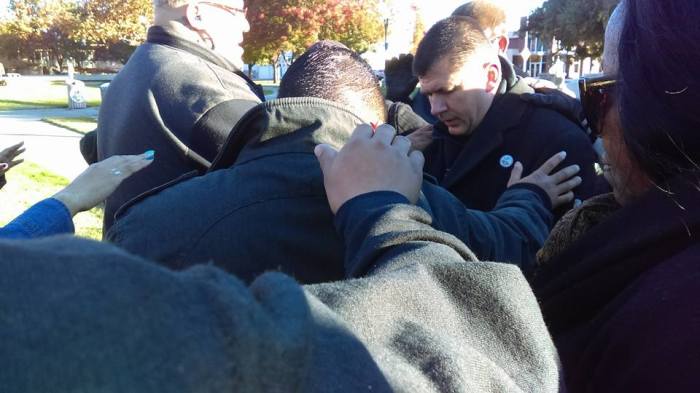 Mayor Anthony Silva prays with constituents at a rally outside city hall in Stockton, California, on November 16, 2015.