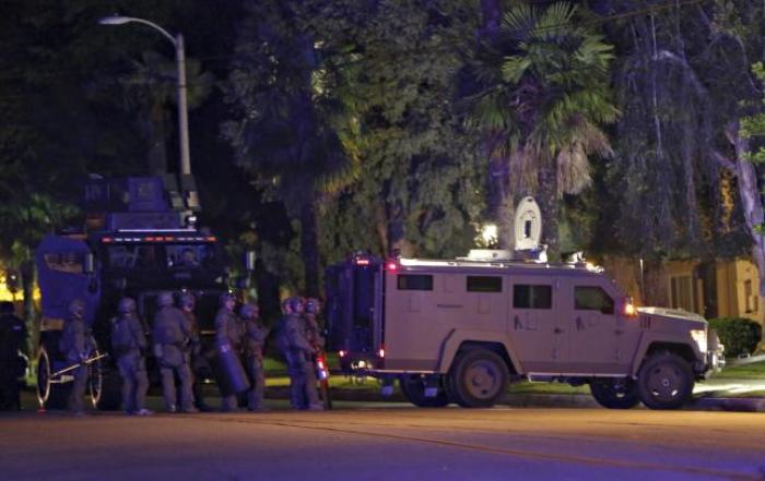 Police officers and their vehicles line the street outside the house of one of the suspects in a mass shooting in Redlands, California December 2, 2015.