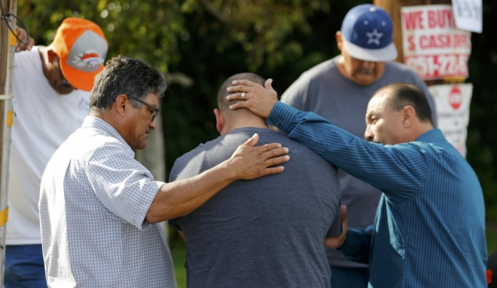 Neighbours comfort Jose Gonzales (centre), who was prevented from returning to his wife and his home at the scene of the investigation around the area of the SUV vehicle where two suspects were shot by police following a mass shooting in San Bernardino, California, December 3, 2015. Authorities on Thursday were working to determine why Syed Rizwan Farook 28, and Tashfeen Malik, 27, opened fire at a holiday party of his co-workers in Southern California, killing 14 people and wounding 17 in an attack that appeared to have been planned.