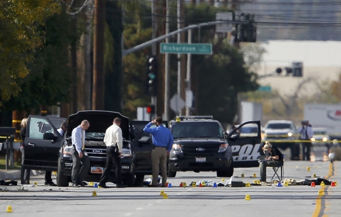 Police and Sheriff's Office Crime Scene investigators examine evidence at the scene of the investigation around an SUV where two suspects were shot by police following a mass shooting in San Bernardino, California, December 3, 2015. Authorities on Thursday were working to determine why Syed Rizwan Farook 28, and Tashfeen Malik, 27, opened fire at a holiday party of his co-workers in Southern California, killing 14 people and wounding 17 in an attack that appeared to have been planned.