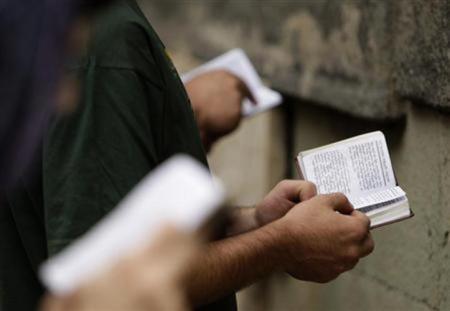 Believers read the bible during a religious service marking the Day of the Virgin Mary at Sioni Cathedral in Tbilisi, Georgia, August 28, 2011.