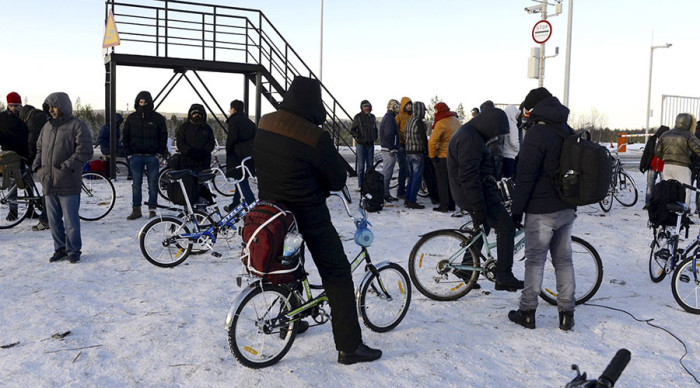 Refugees and migrants gather near a check point on the Russian-Norwegian border outside Nickel (Nikel) settlement in Murmansk region, Russia, October 30, 2015.