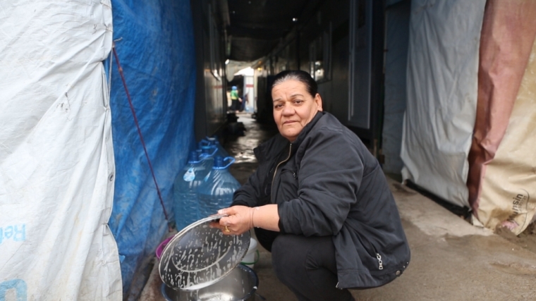 A refugee washes dishes.