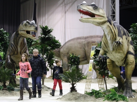 Children walk by life-sized Ceratosaurus dinosaur models in Vienna February 7, 2014. The travelling exhibition 'World of Dinosaurs' shows some 50 life-sized dinosaur models and runs in Vienna until February 23.