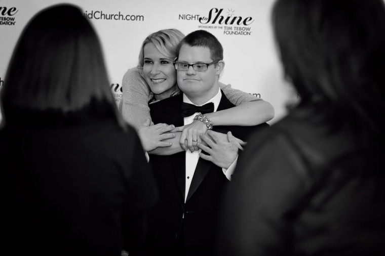 A guest and 'buddy' pose for cameras on the red carpet at the Night to Shine prom event co-hosted by Liquid Church and sponsored by the Tim Tebow Foundation, Morristown, New Jersey, February 13, 2015.