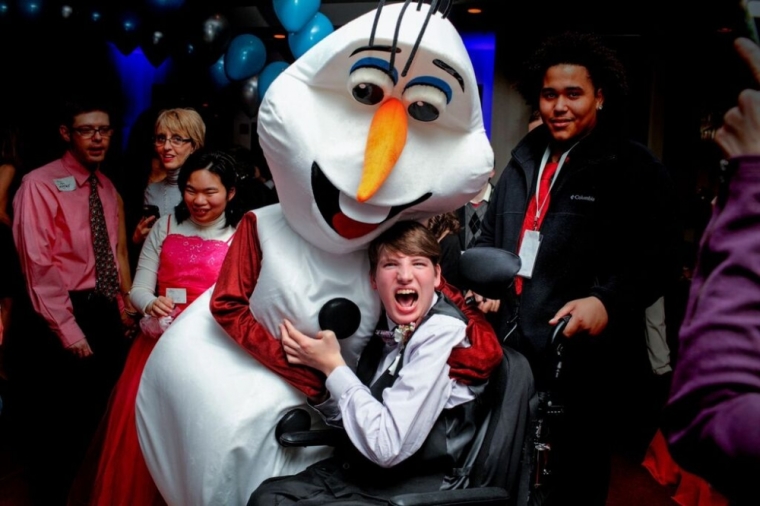 A guest poses with an event mascot at the Night to Shine prom co-hosted by Liquid Church and sponsored by the Tim Tebow Foundation, Morristown, New Jersey, February 13, 2015.