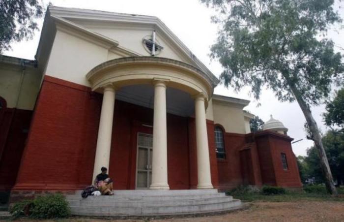 A woman holds her baby as she sits outside a church in New Delhi July 6, 2008.